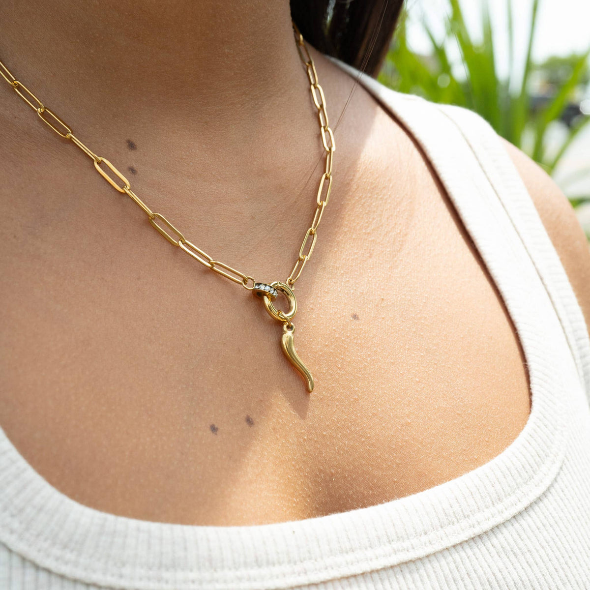 Side view of gold paperclip charm holder necklace