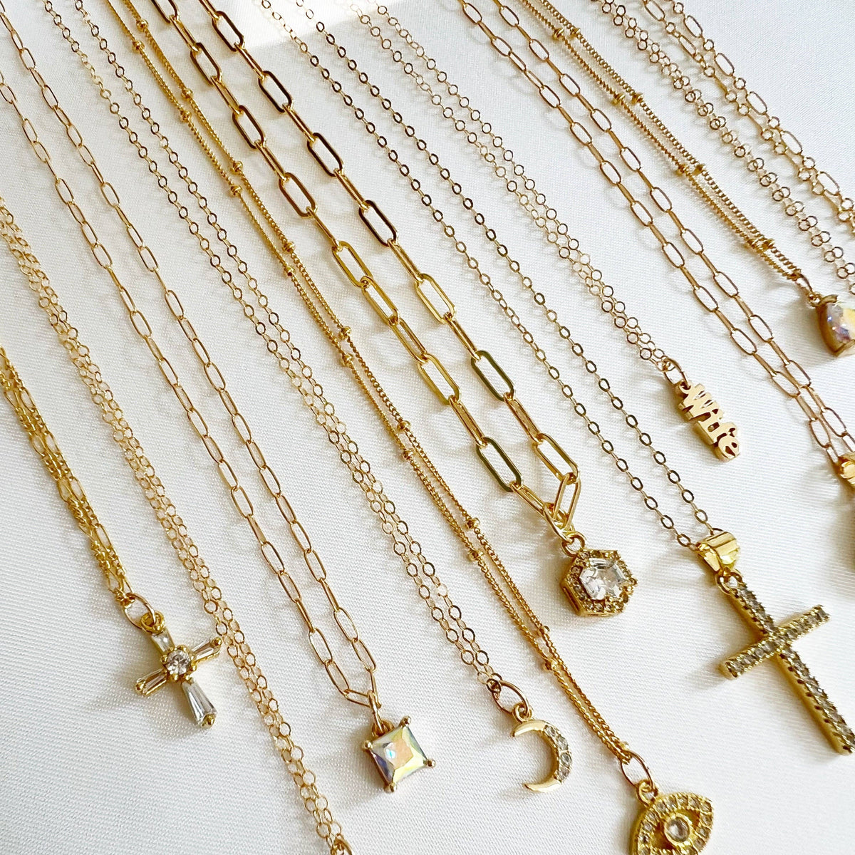 Petite gold cross necklace presented in luxury gift packaging