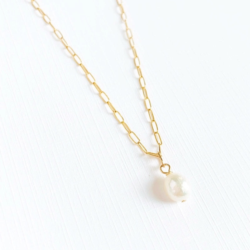 Close up of a dainty baroque pearl necklace gold jewelry details