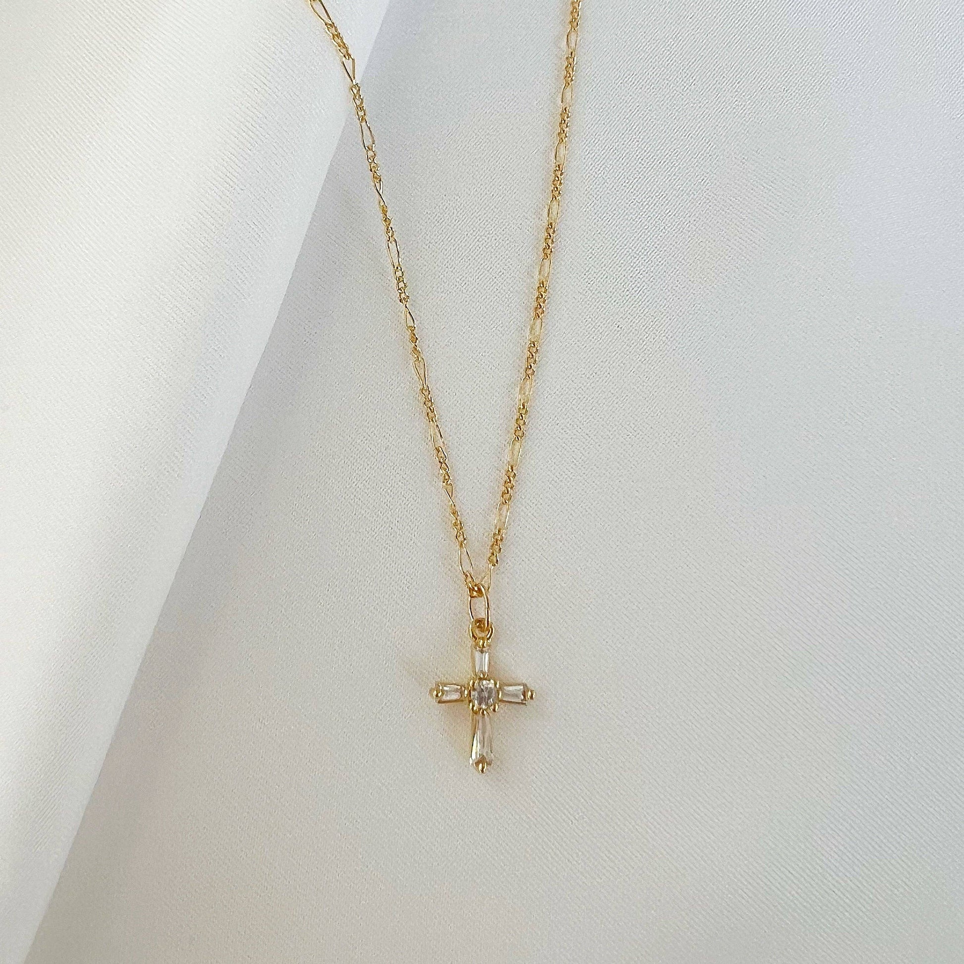 Close-up of petite baguette cross pendant on gold-filled necklace