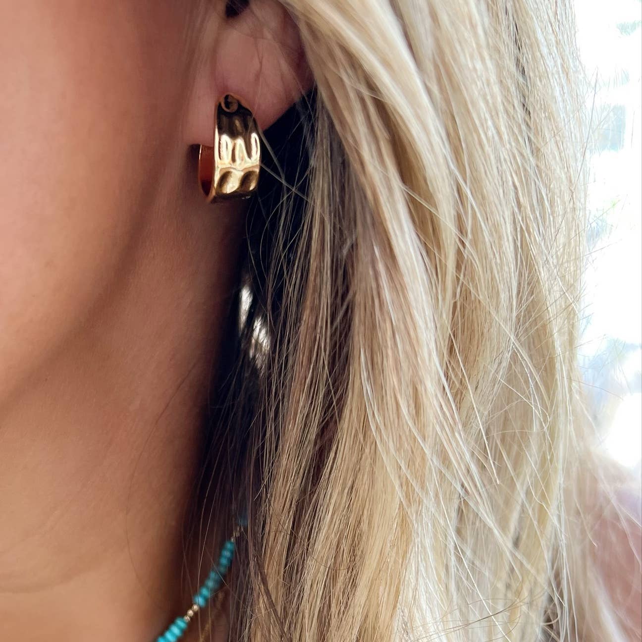 Close-up of textured 14K gold-filled hammered hoop earrings