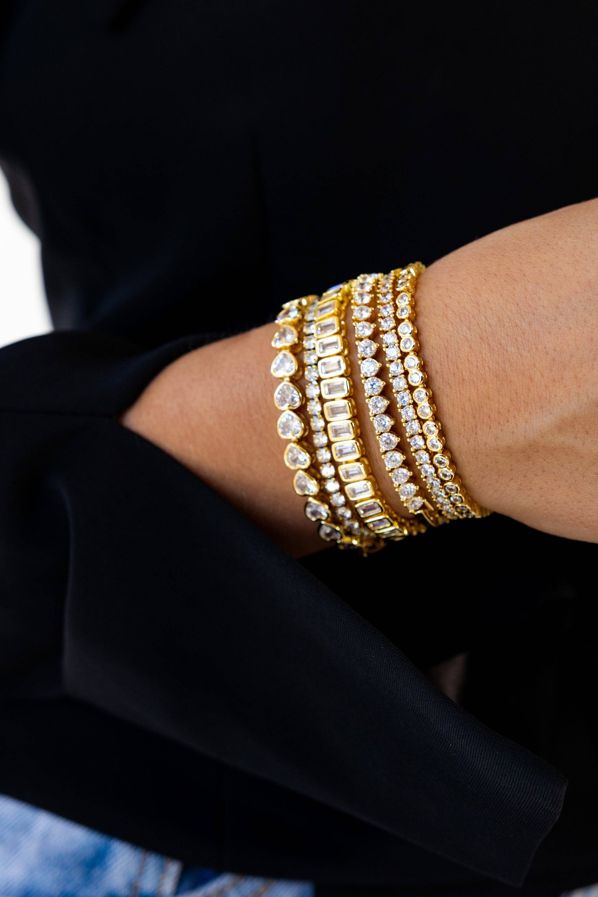 Gold CZ tennis bracelet styled with layered everyday jewelry