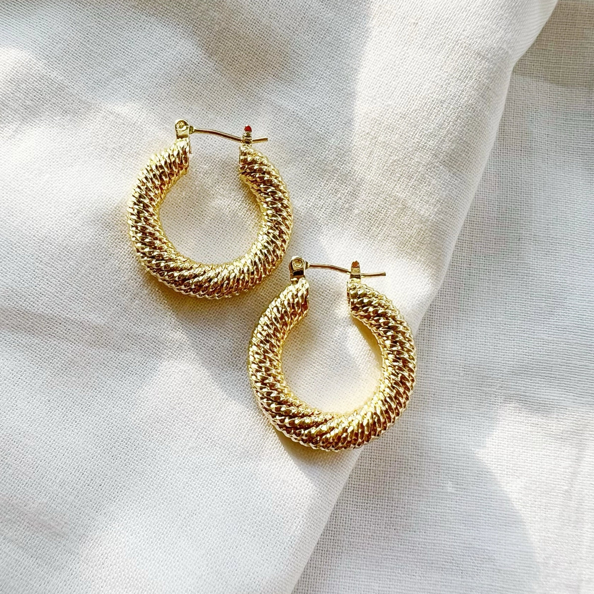 Close-up of woven texture on 14K gold-filled twist hoop earrings
